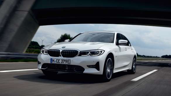 BMW Serie 3 Híbrido Enchufable 2021 G20, vista de tres cuartos del frontal, circulando BMW Serie 3 Híbrido Enchufable 2021 G20, vista de tres cuartos del frontal, circulando por la calle