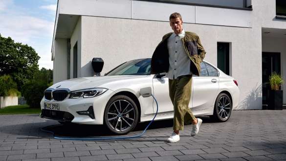 BMW Serie 3 Híbrido Enchufable 2021 G20, vista de tres cuartos del frontal, carga BMW Serie 3 Híbrido Enchufable 2021 G20, vista de tres cuartos del frontal, carga con modelo