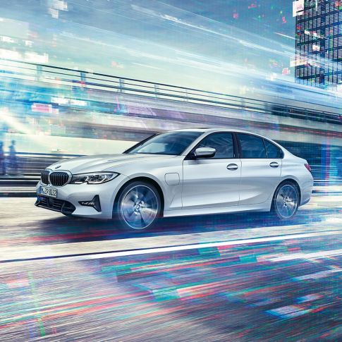 BMW Serie 3, vista lateral del BMW Serie 3 330e circulando Vista lateral del BMW Serie 3 330e circulando con la ciudad de fondo.
