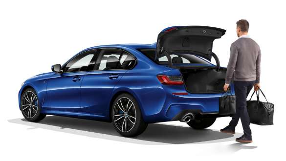 BMW Serie 3 (G20), accionamiento automático del portón trasero. Toma de tres cuartos de la zaga del BMW Serie 3 (G20) parado con conductor, que abre automáticamente el portón trasero con el pie.