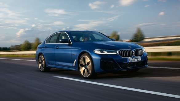 BMW Serie 5 Híbrido Enchufable 2021 G30 vista de tres cuartos del frontal, en marcha BMW Serie 5 Híbrido Enchufable 2021 G30 vista de tres cuartos del frontal, en marcha por una carretera