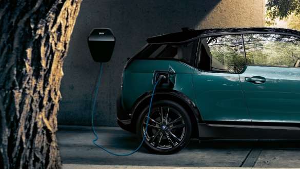 BMW i3 I01 2018 junto a BMW Wallbox BMW i3 I01 2018 Blue Ridge Mountain con detalles Frozen Grey metallic, cargándose en un BMW Wallbox