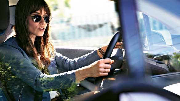 Mujer con gafas de sol conduciendo un BMW i3 I01 Mujer con gafas de sol conduciendo un BMW i3 I01