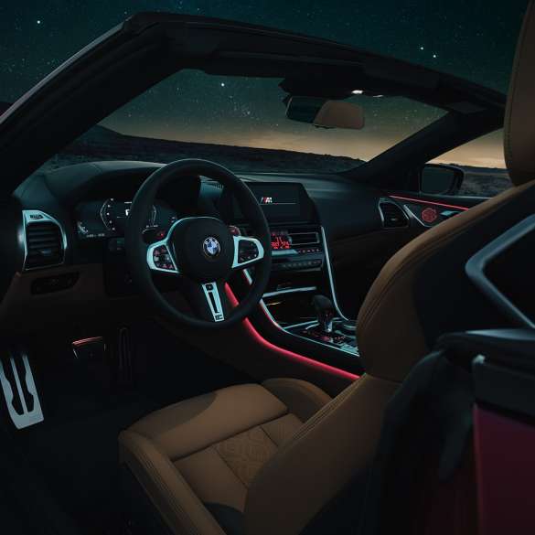 BMW M8 Competition Cabrio, puesto de conducción F91. BMW M8 Competition Cabrio, puesto de conducción de noche con volante M de cuero y luz ambiente roja F91.