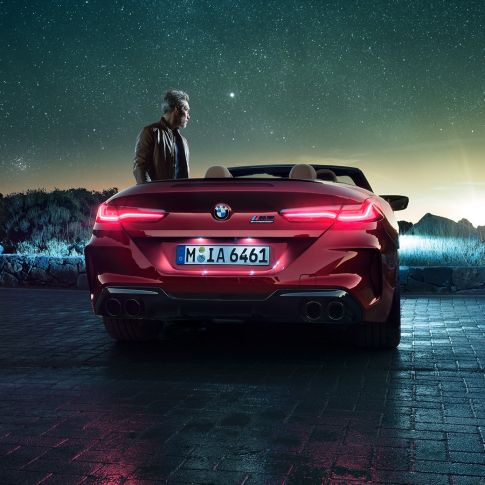 BMW M8 Competition Cabrio, vista trasera. BMW M8 Competition Cabrio en Motegi Rot metalizado con la capota abierta, vista trasera, del superdeportivo de BMW.