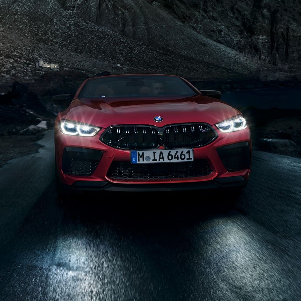 BMW M8 Competition Cabrio, vista frontal F91. BMW M8 Competition Cabrio en Motegi Rot metalizado con los faros encendidos, vista frontal, del BMW descapotable F91.