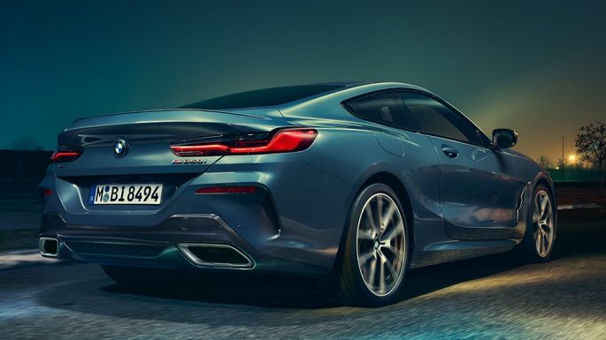 BMW M850i xDrive Coupé, vista de la zaga. BMW M850i xDrive Coupé en Barcelona Blau metalizado, vista de la zaga, en marcha, por la noche.