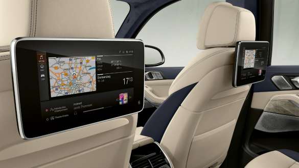 BMW X7 M con sistema de entretenimiento en la parte trasera Professional BMW X7 M, interior, vista inclinada del sistema de entretenimiento en la parte trasera Professional detrás de los asientos delanteros, G07
