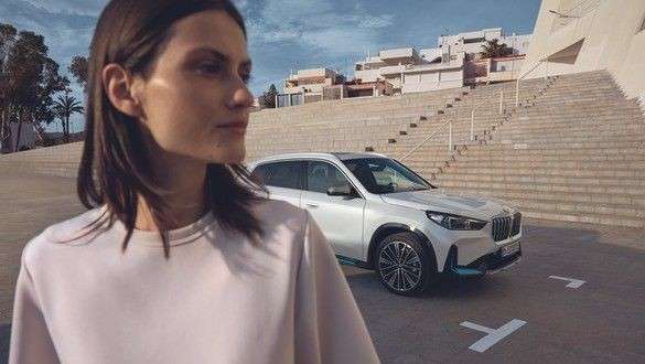 Neumático BMW, mujer al volante de coche en marcha Neumático BMW, mujer al volante de coche en marcha