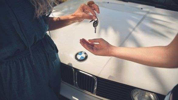 Neumáticos BMW, hombre delante de un BMW i4 en un punto de carga Neumáticos BMW, hombre delante de un BMW i4 en un punto de carga