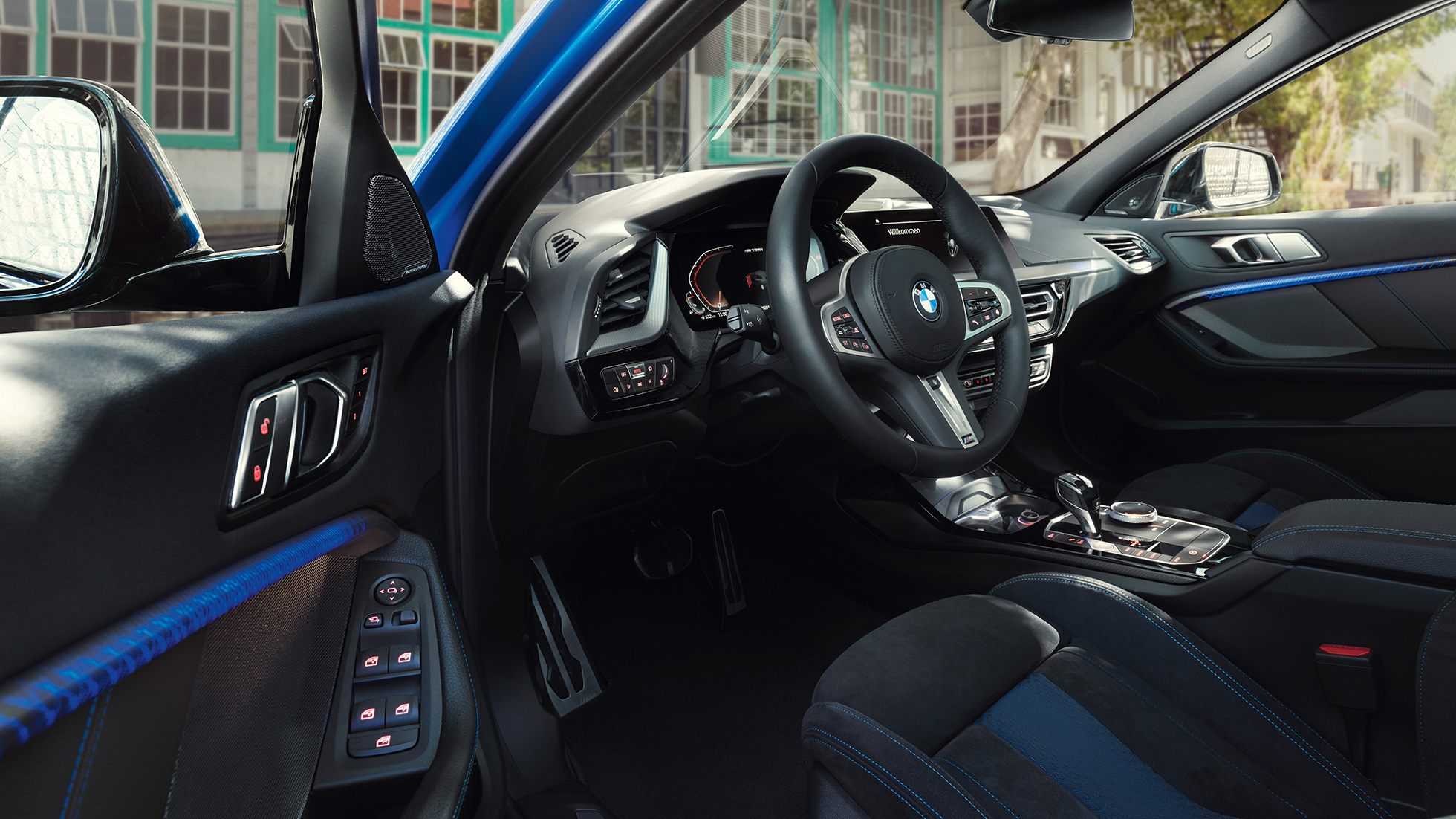 Puesto de conducción del BMW Serie 1 Puesto de conducción del BMW Serie 1 2019 con volante M de cuero mientras la puerta del conductor está abierta.