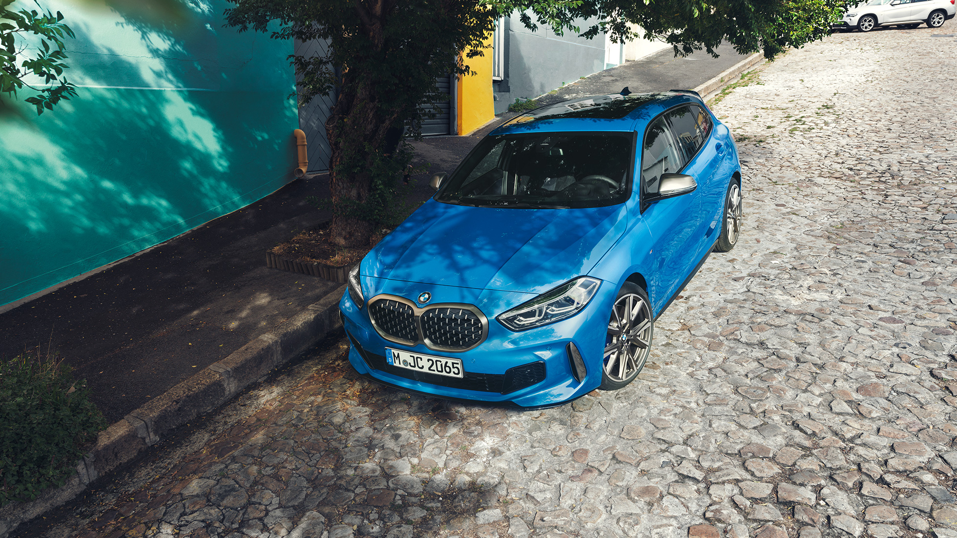 BMW Serie 1 en carretera F40 BMW Serie 1 2019 en color Misano Blau metalizado, vista aérea aparcado junto a la carretera F40.