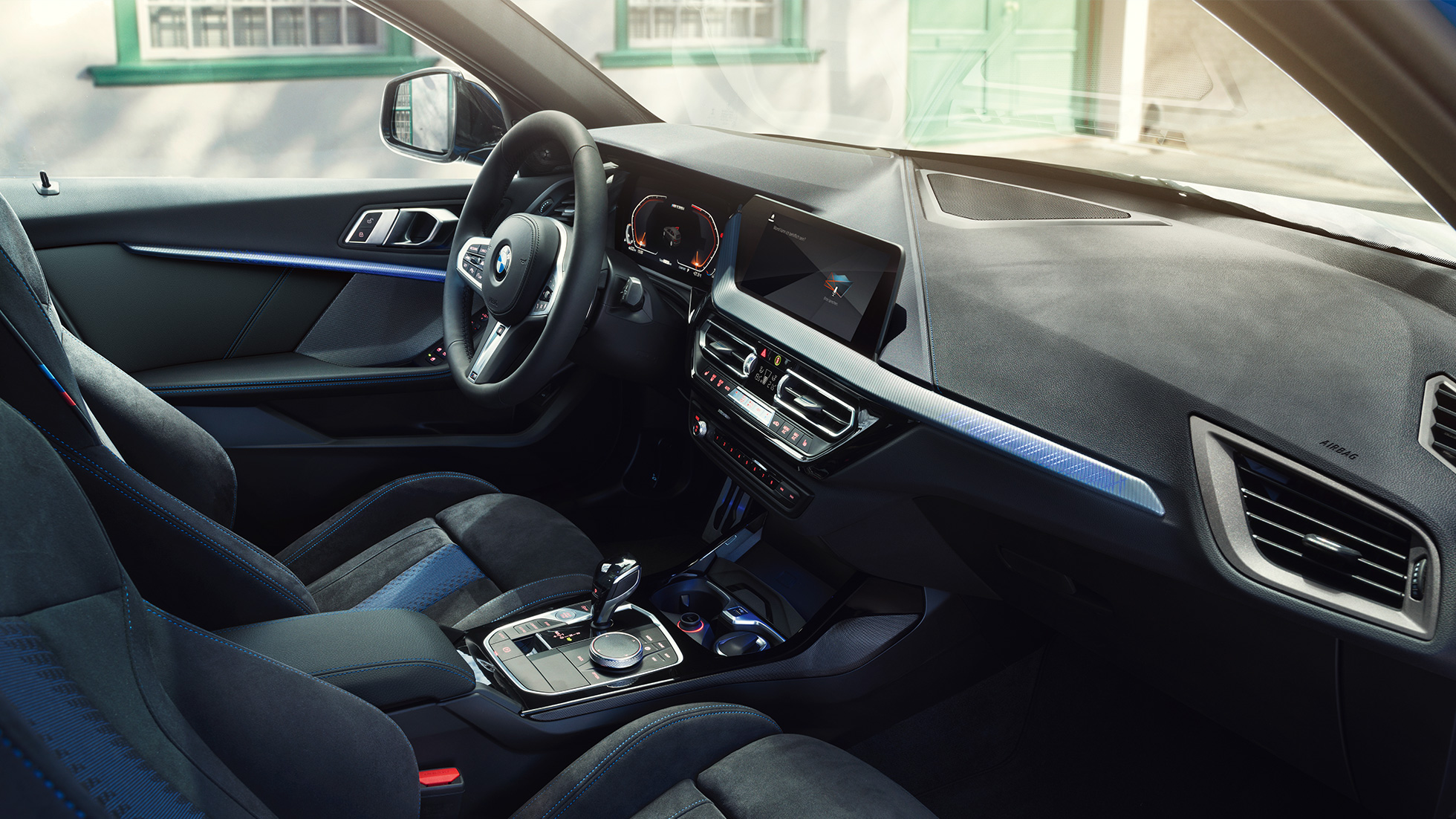 Interior deportivo del BMW Serie 1 Puesto de conducción del BMW Serie 1 2019 con asientos deportivos M, volante M de cuero y molduras interiores iluminadas.