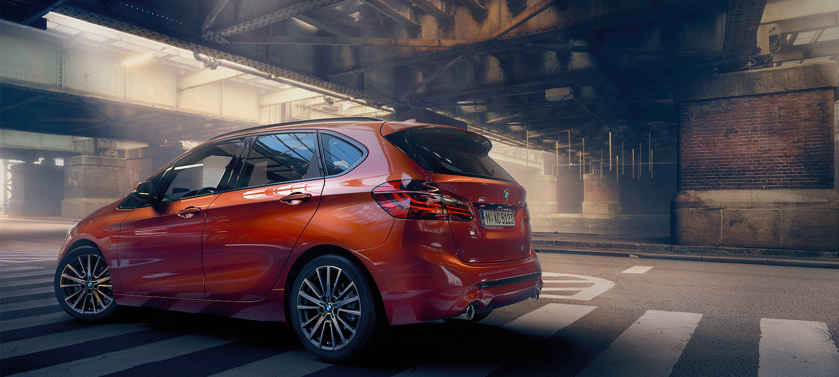 Vista lateral BMW Serie 2 Active Tourer BMW Serie 2 Active Tourer F45 Renovación 2018 Sunset Orange metalizado, vista lateral, parado en un pabellón