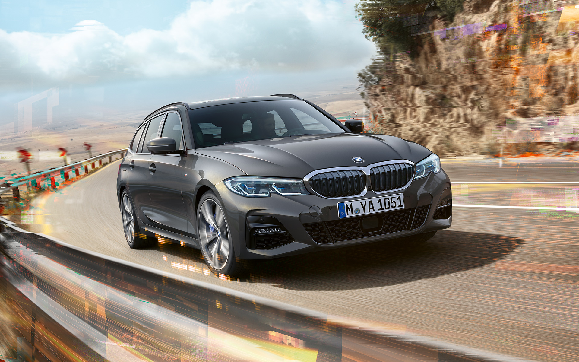 BMW Serie 3 Touring (G21), toma de tres cuartos del frontal, diseño BMW Serie 3 Touring (G21) Dravit Grey, toma de tres cuartos del frontal del vehículo en marcha sobre un puente delante de un entorno rural