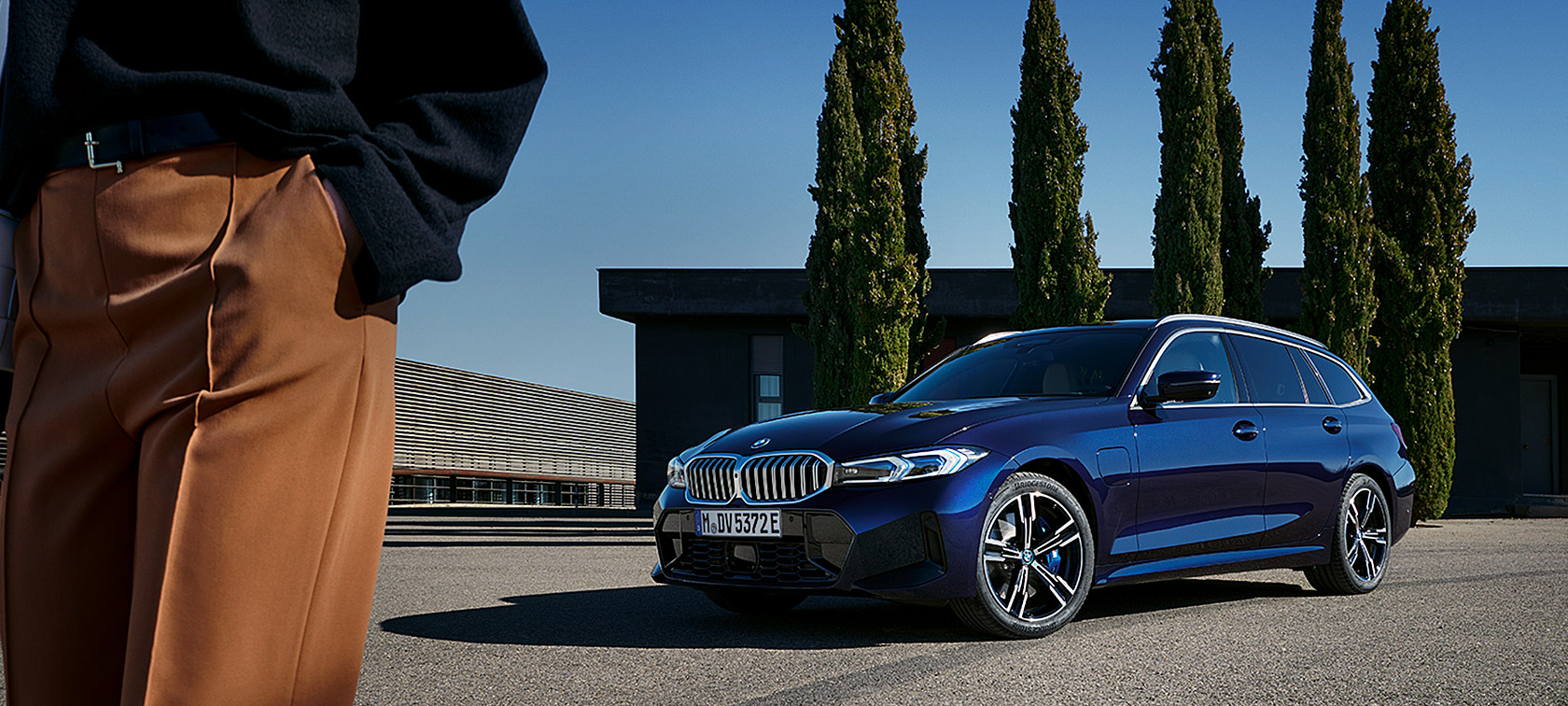 BMW Serie 3 Touring LCI G21 Tanzanite Blue II, vista de tres cuartos del frontal, parado, delante de árboles