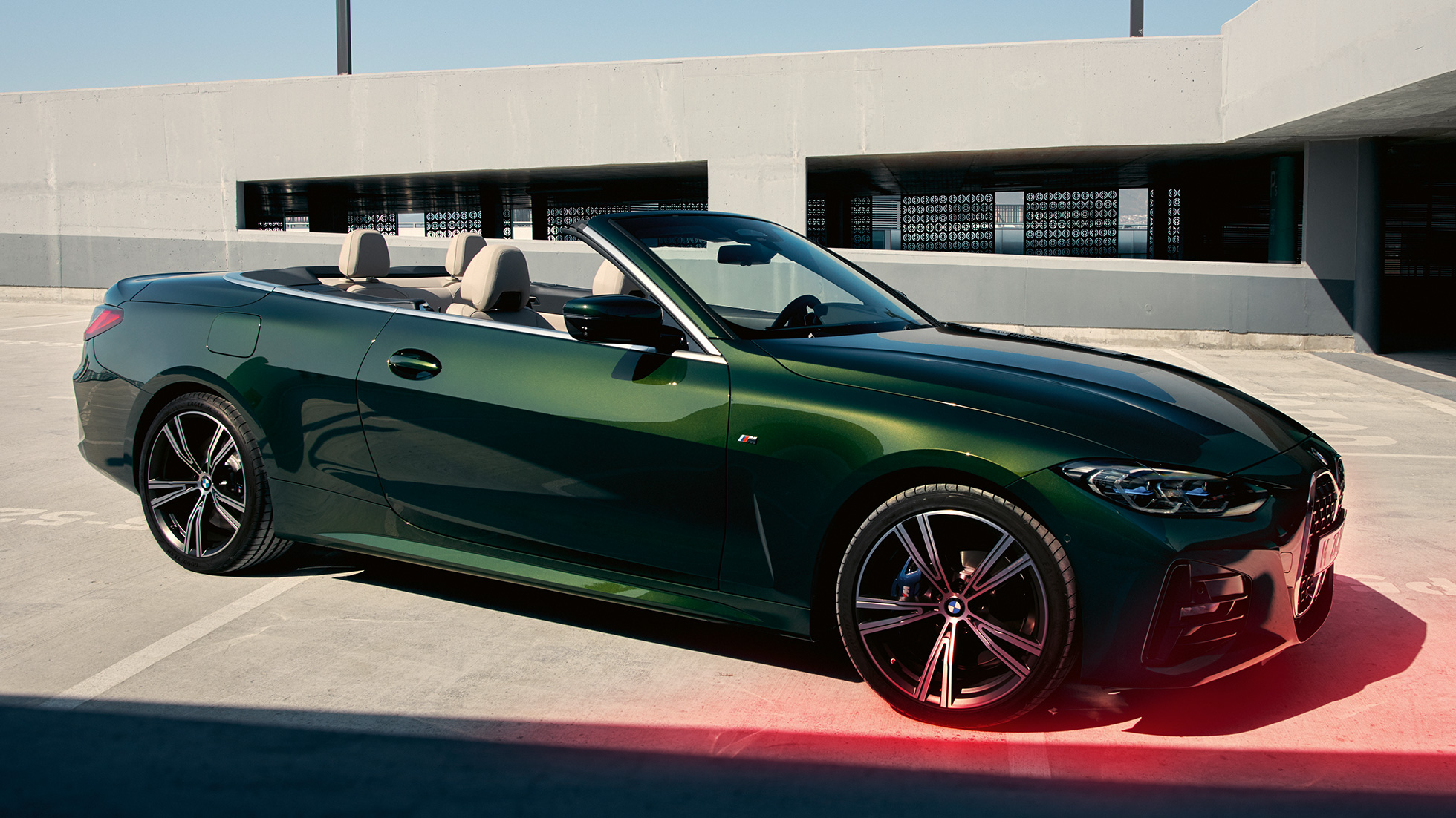 Vista de tres cuartos del frontal BMW Serie 4 Cabrio G23 2020 con hombre BMW Serie 4 Cabrio G23 2020 Sanremo Green metalizado, vista de tres cuartos del frontal, con un hombre al lado