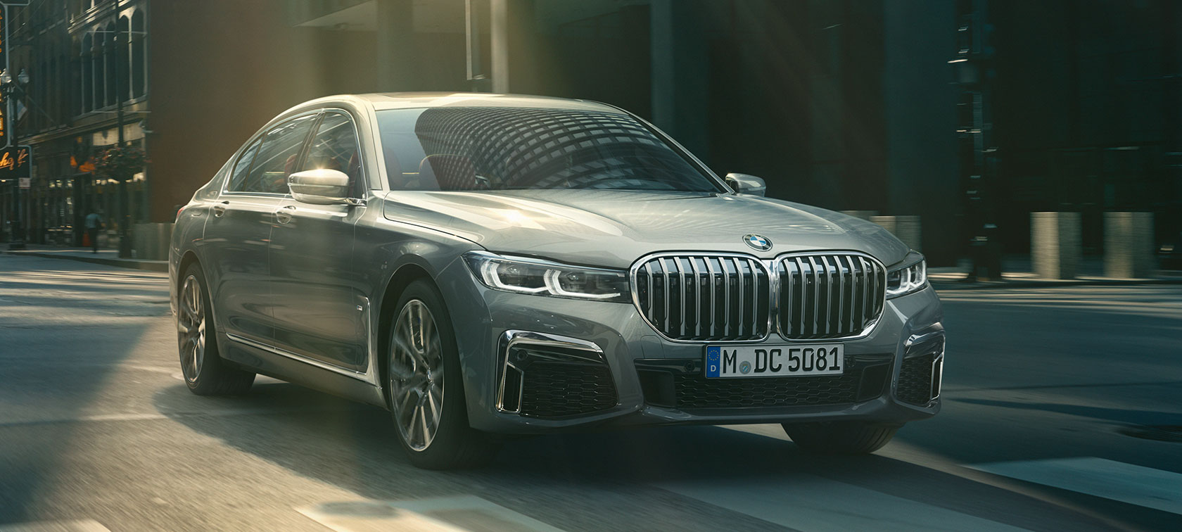 BMW Serie 7 en gris circulando, en vista de tres cuartos del frontal BMW Serie 7 en gris circulando por la ciudad, vista de tres cuartos del frontal