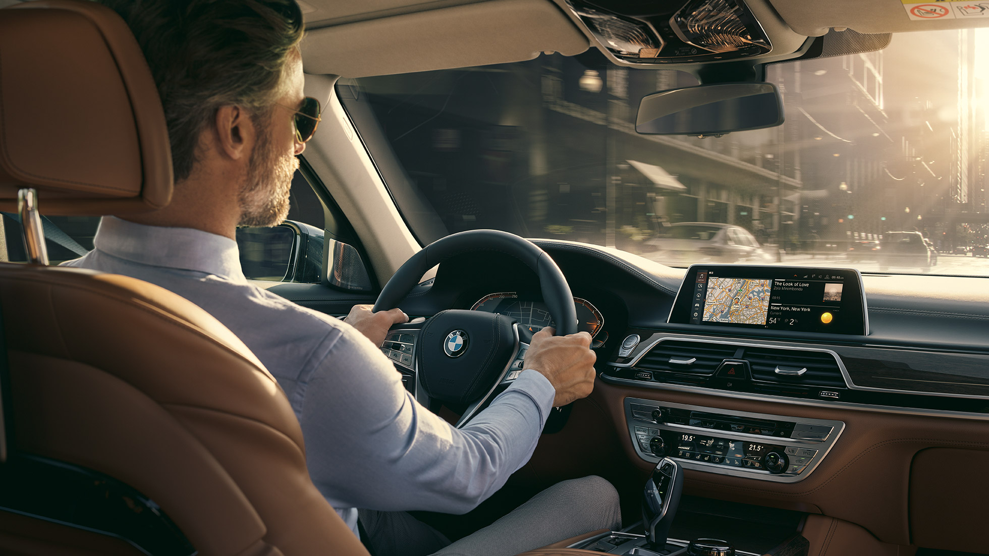 Funciones de conectividad del BMW Serie 7 BMW Serie 7: hombre sentado en el BMW y utilizando las funciones de conectividad