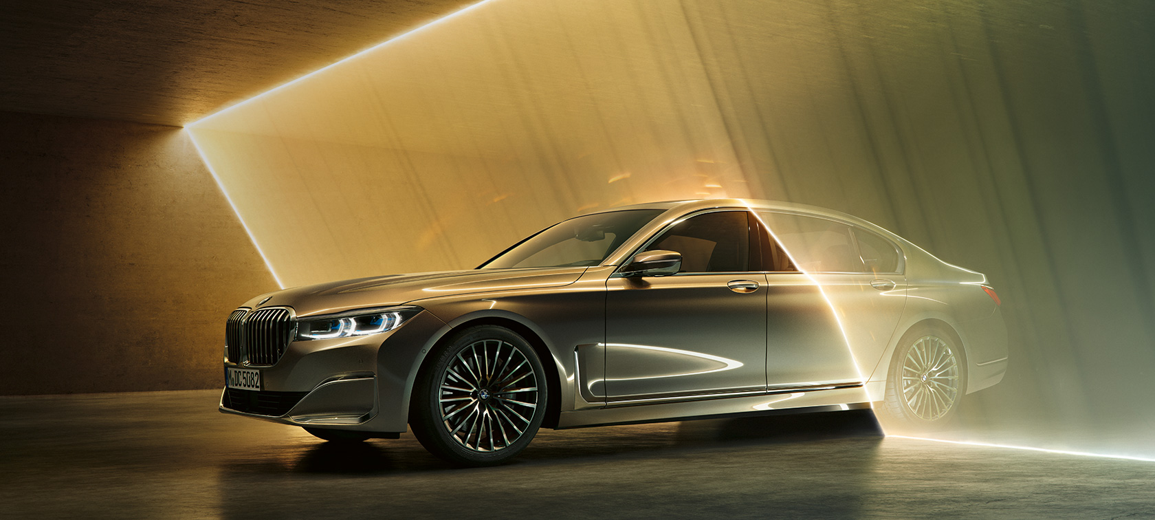 BMW Serie 7: BMW gris en vista de tres cuartos del frontal rodeado de luces BMW Serie 7 en vista de tres cuartos del frontal