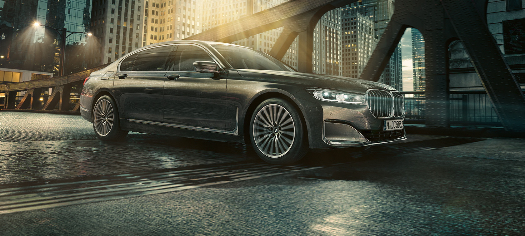 BMW Serie 7 Vista lateral BMW Serie 7, en vista lateral, con la puerta abierta delante de un hotel iluminado