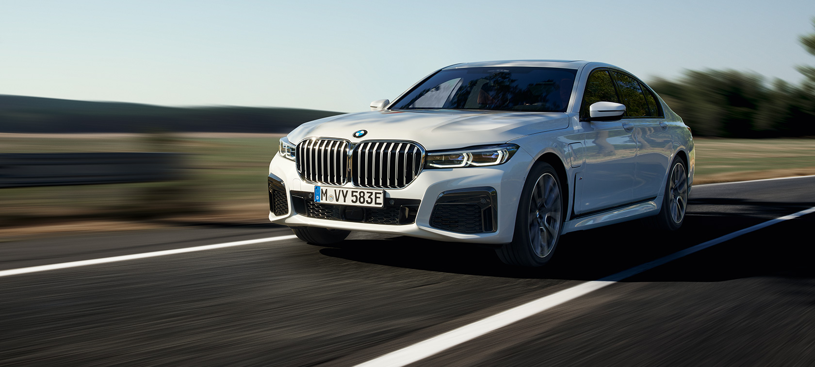 BMW Serie 7 Híbrido Enchufable G11 G12 Vista de tres cuartos del frontal, en marcha BMW Serie 7 Híbrido Enchufable G11 G12 Vista de tres cuartos del frontal, en marcha por la carretera