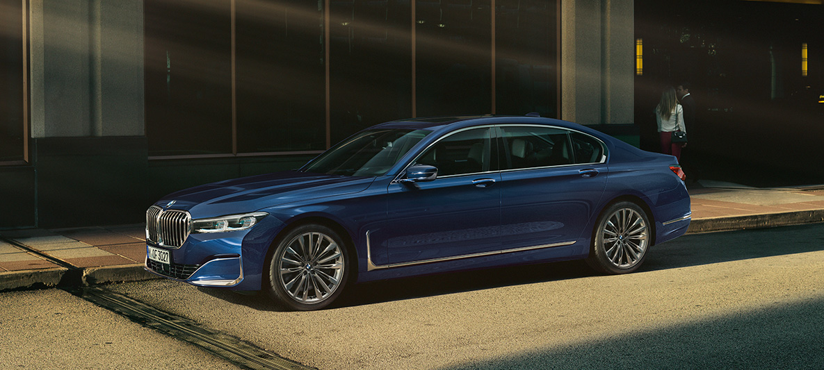BMW Individual Serie 7, vista lateral BMW Individual Serie 7 en rojo, en vista lateral, ante un fondo urbano