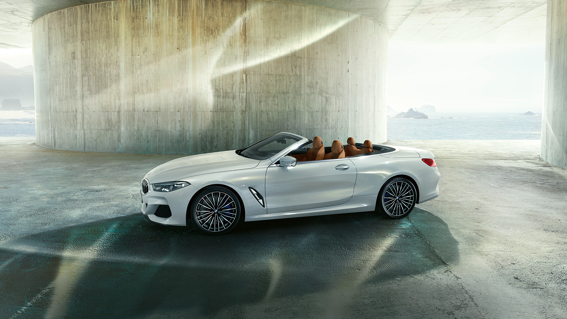 BMW M850i xDrive en Mineralweiss metalizado, vista lateral con la capota abierta. BMW M850i xDrive en Mineralweiss metalizado, vista lateral con la capota abierta.