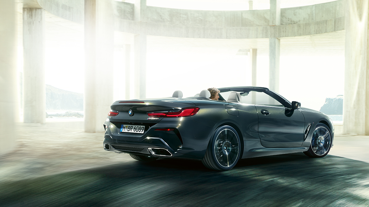 BMW M850i xDrive con capota abierta, en marcha, vista lateral. BMW M850i xDrive con capota abierta, en marcha, vista lateral.