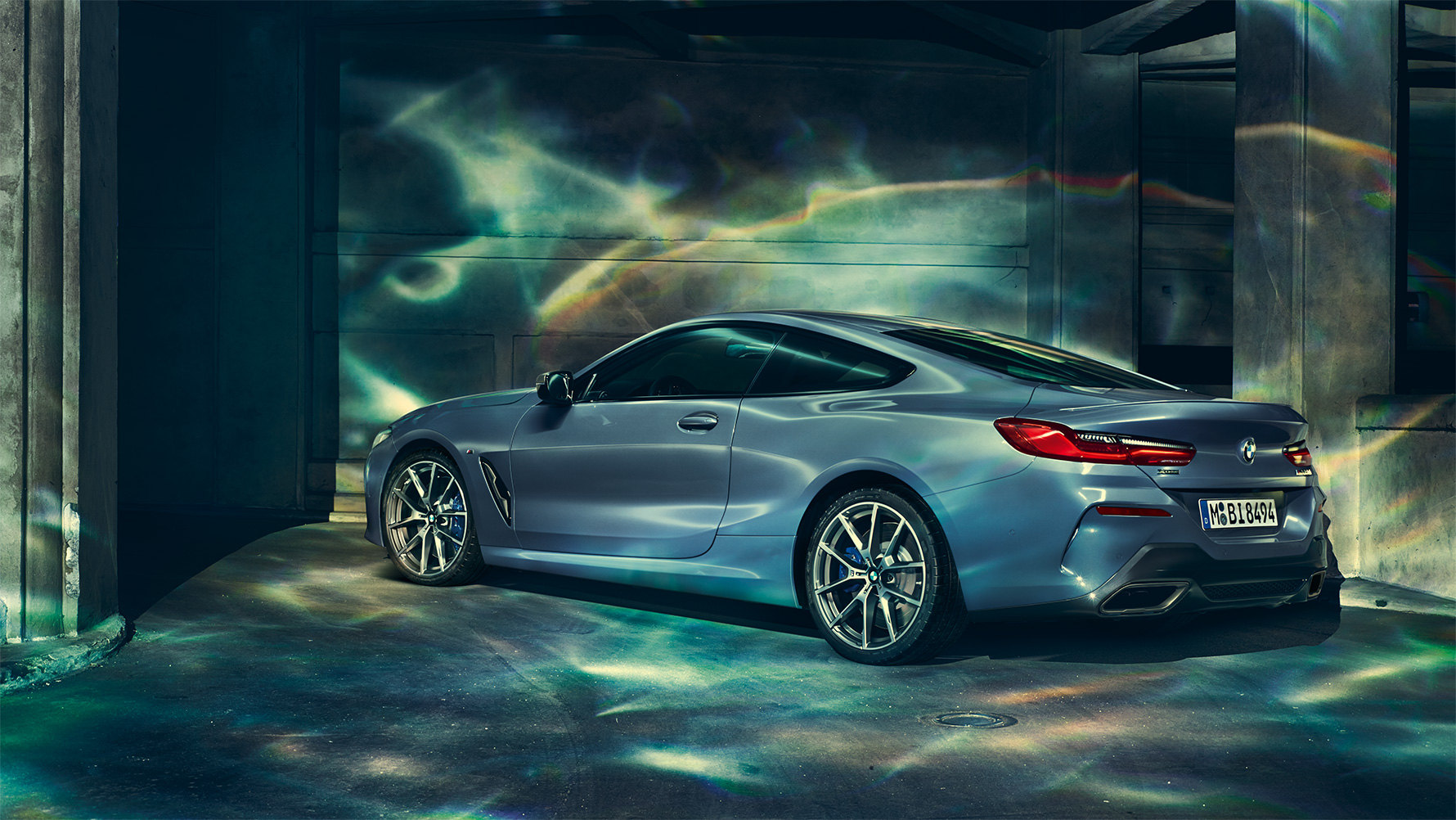 BMW Serie 8 Series Coupé, imagen de tres cuartos de la zaga Imagen de tres cuartos de la zaga del BMW Serie 8 Coupé por la noche con la ciudad al fondo.