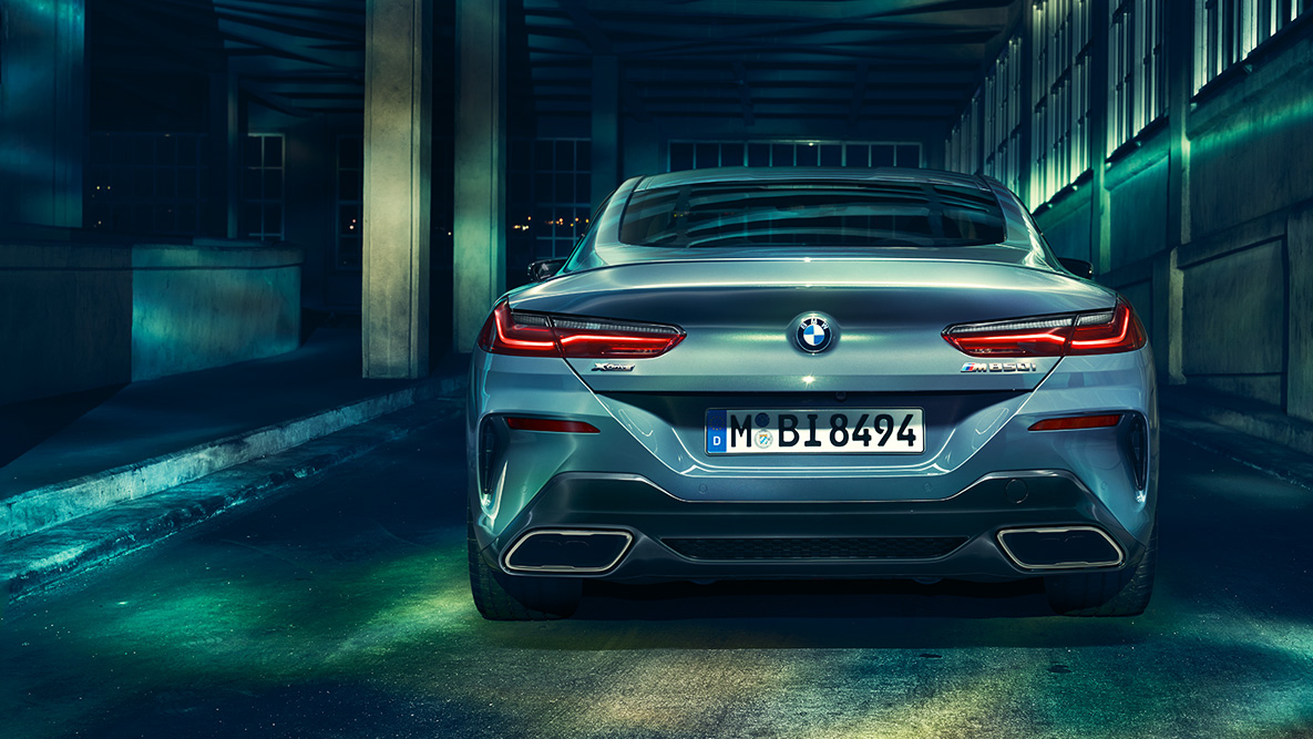 BMW Serie 8 Coupé, vista de la zaga. Vista trasera del BMW Serie 8 Coupé de noche en un entorno urbano.