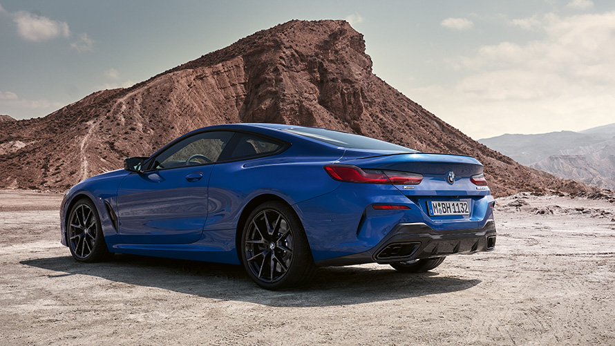 Vista de tres cuartos de la zaga BMW Serie 8 Coupé Paquete M Sport G15 LCI Renovación 2022 BMW Serie 8 Coupé Paquete M Sport G15 LCI Renovación 2022 M Portimao Blue metalizado, vista de tres cuartos de la zaga, parado, ante rocas