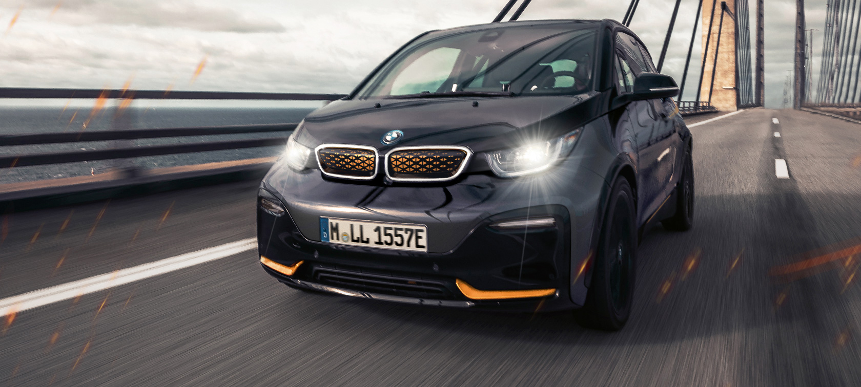 BMW i3 Unique Forever Edition I01 Storm Bay con acentuación en Frozen E-Copper metalizado, vista de tres cuartos del frontal circulando por la autopista