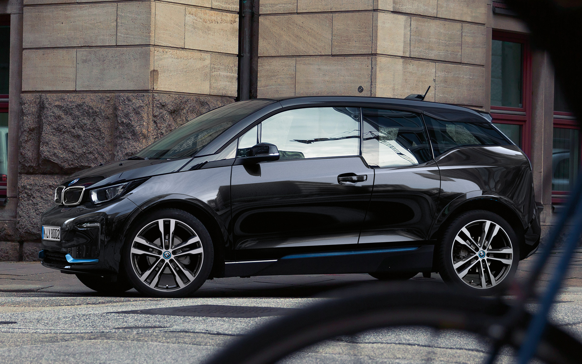 BMW i3s I01 2018 Fluid Black con detalles BMW i Blue, vista lateral, en marcha, en un entorno urbano