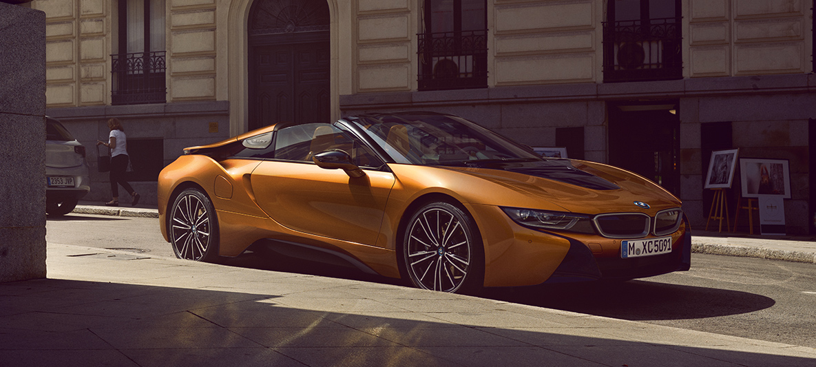Vista lateral del BMW i8 Roadster en entorno urbano. El deportivo híbrido enchufable Vista lateral del BMW i8 Roadster en entorno urbano. El deportivo híbrido enchufable