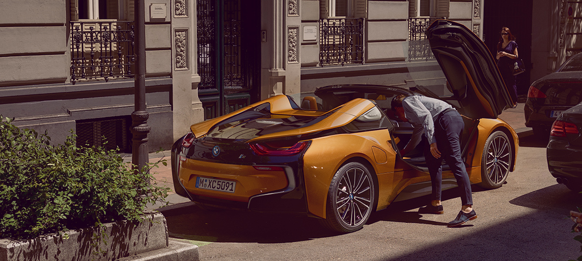 Vista lateral trasera del BMW i8 Roadster con sus puertas de ala de gaviota abiertas Vista lateral trasera del BMW i8 Roadster con sus puertas de ala de gaviota abiertas