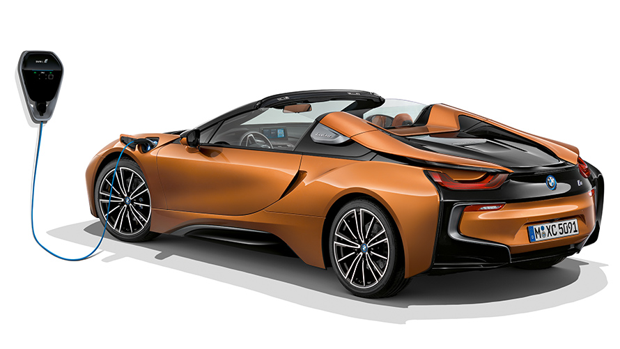 Vista trasera del BMW i8 Roadster cargando. El deportivo híbrido enchufable Vista trasera del BMW i8 Roadster cargando. El deportivo híbrido enchufable