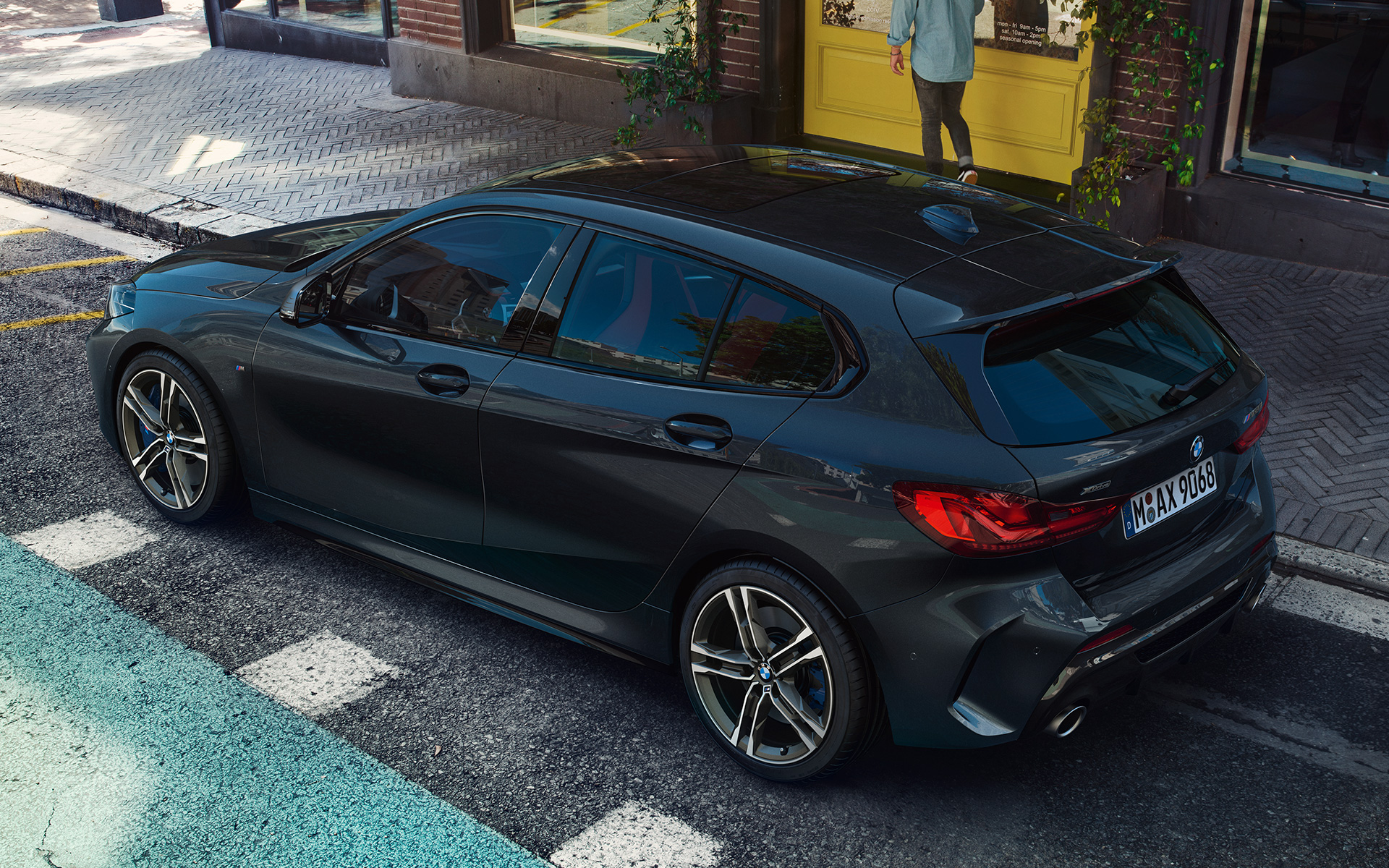 BMW M135i xDrive (F40) en Black Sapphire metalizado, aparcado, vista lateral desde una perspectiva aérea