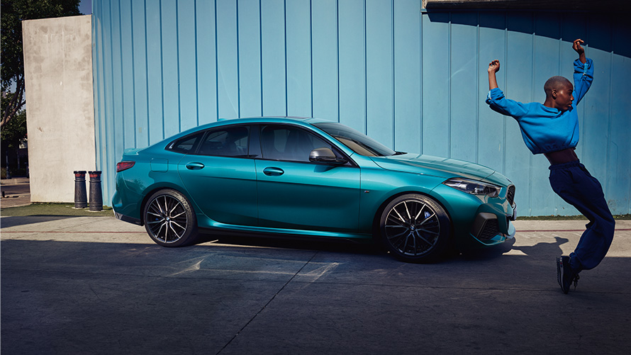 BMW M235i xDrive Gran Coupé F44 vista lateral, con mujer en primer plano BMW M235i xDrive Gran Coupé F44 Snapper Rocks Blue metalizado, vista lateral, con mujer en primer plano