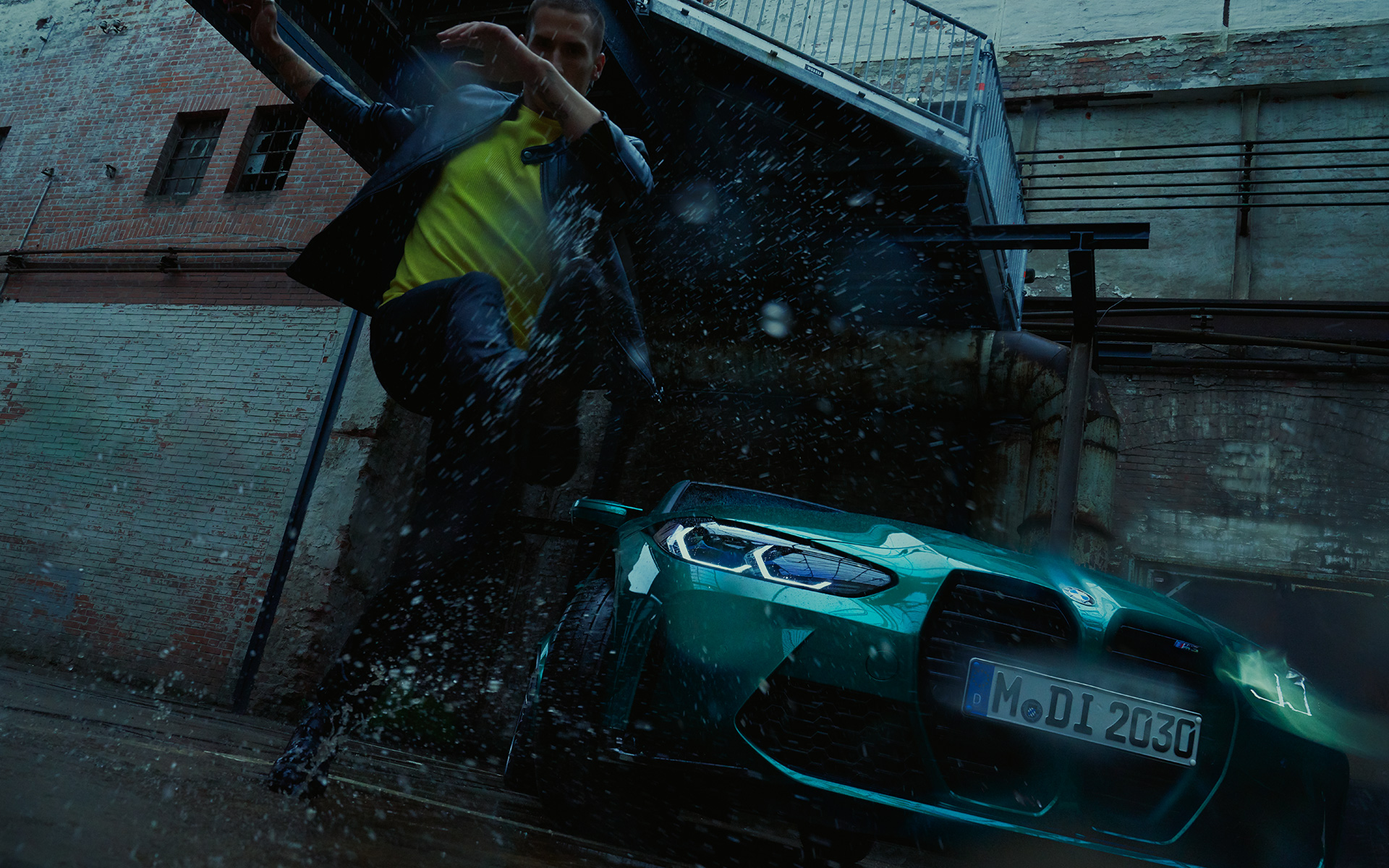 BMW M3 Berlina G80 2020 Isle of Man Green metalizado, vista del frontal, con hombre bajo la lluvia