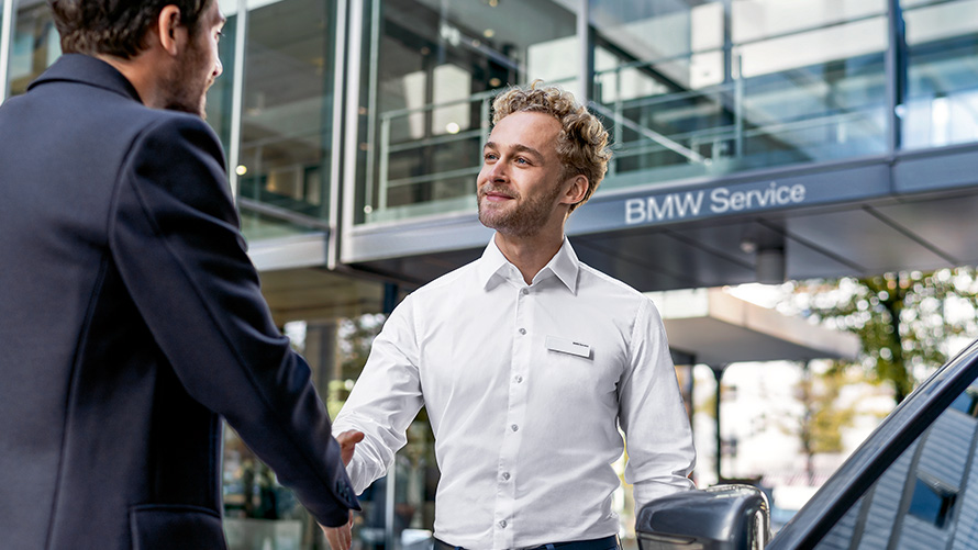Empleado de BMW Service da la bienvenida a clientes Empleado de BMW Service da la bienvenida a clientes