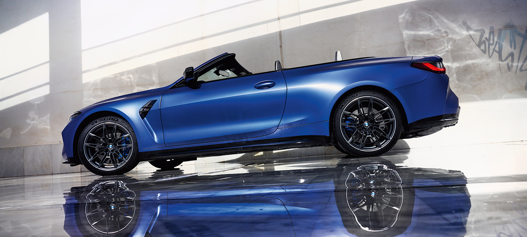 BMW M4 Competition Cabrio con sistema M xDrive G83 2021, vista de tres cuartos del frontal, en marcha BMW M4 Competition Cabrio con sistema M xDrive G83 2021 BMW Individual Frozen Portimao Blau metalizado, vista de tres cuartos del frontal, en marcha