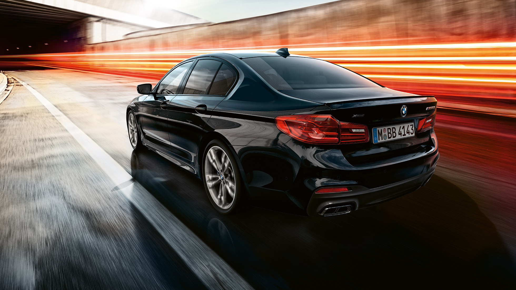 Dinamismo de conducción BMW M550i y BMW M550d, vista de tres cuartos de la zaga en marcha de la berlina deportiva