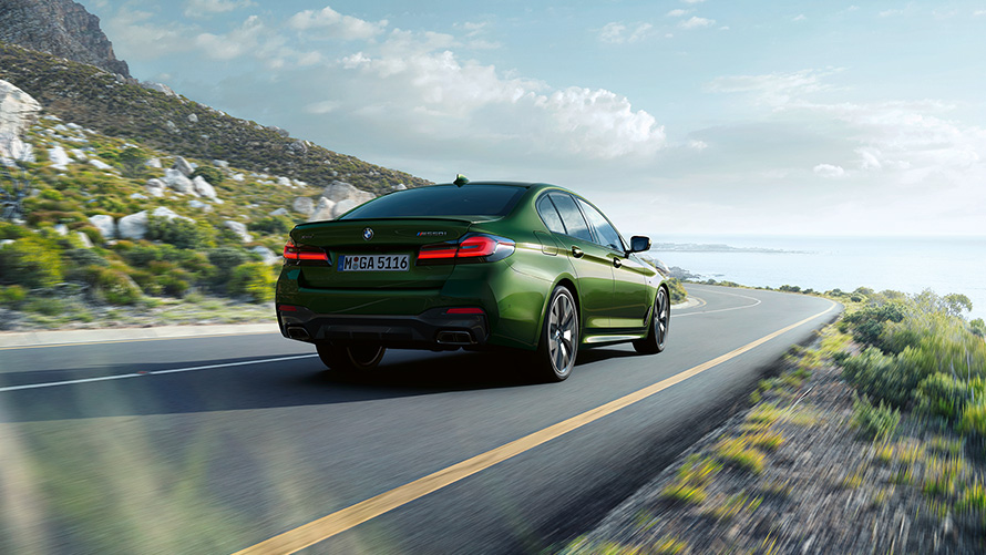 BMW M550i xDrive Berlina G30 LCI Renovación 2020 BMW Individual Verde Ermes metalizado, vista de tres cuartos de la zaga, en marcha