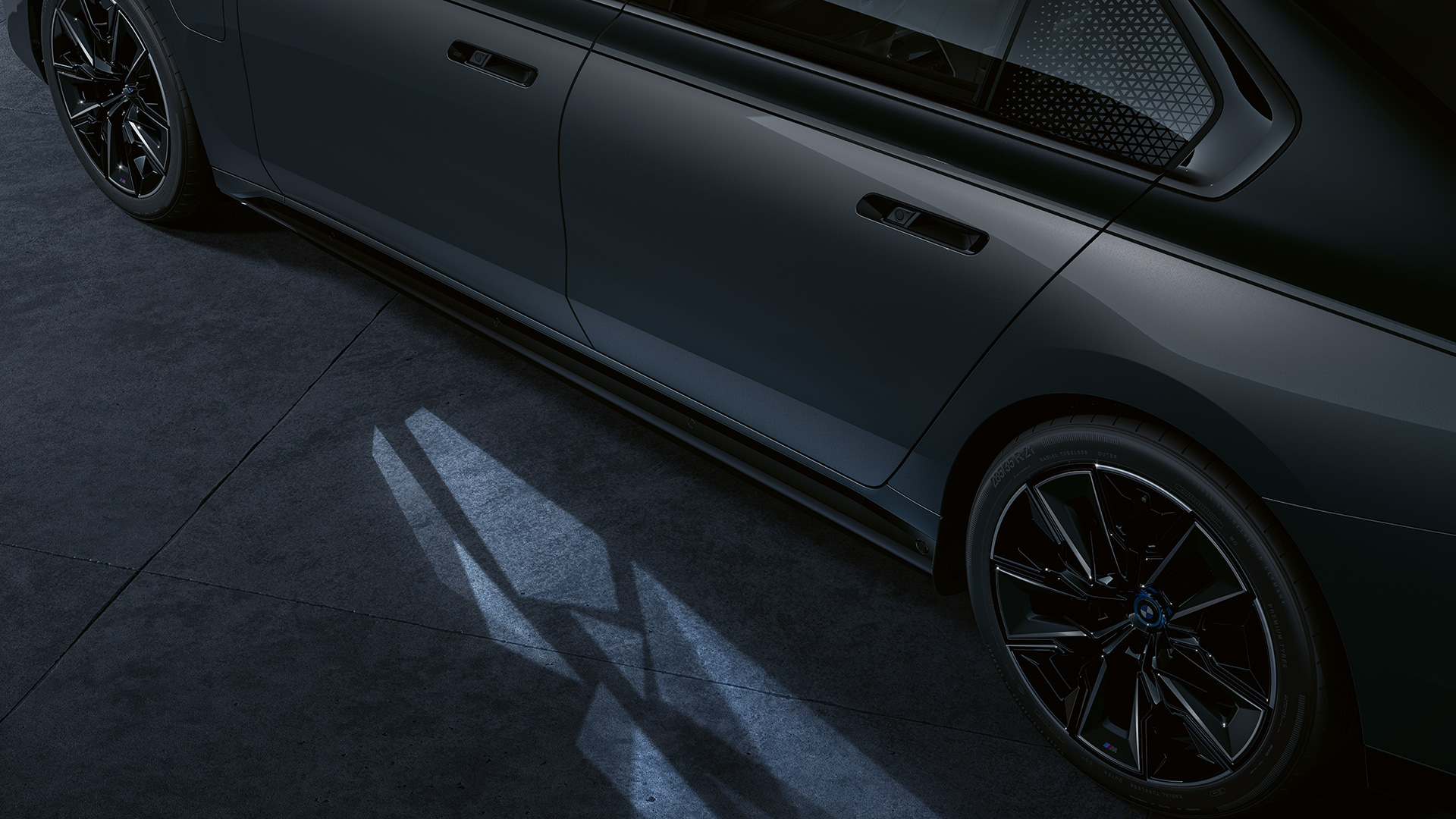 Concepto de iluminación BMW M760e xDrive Berlina G70 Concepto de iluminación BMW M760e xDrive Berlina G70 Pintura bicolor BMW Individual Black Sapphire metalizado BMW Individual Dravit Grey metalizado, lateral, primer plano, con Welcome Light Carpet encendida