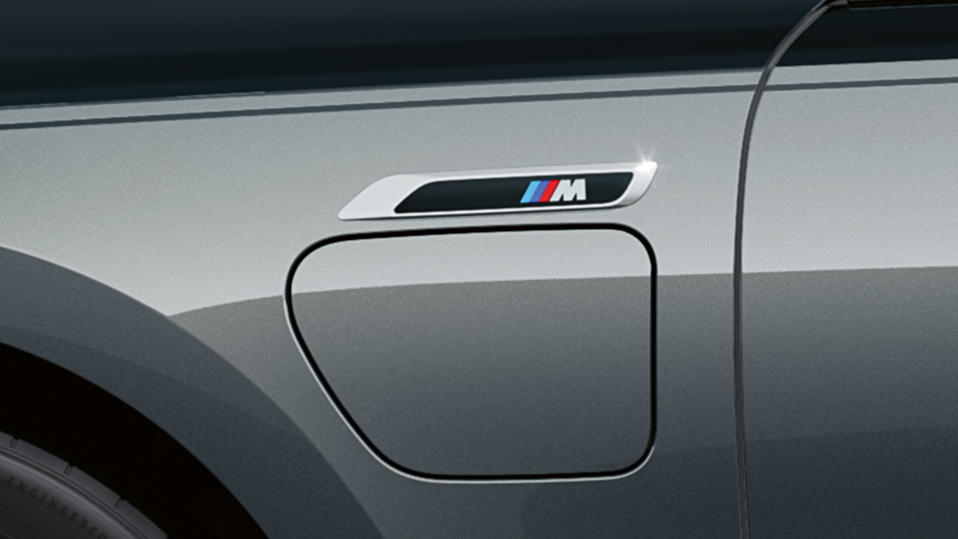 Emblema "M" BMW M760e xDrive Berlina G70 Emblema "M" BMW M760e xDrive Berlina G70 Paquete M Performance, pintura bicolor BMW Individual Black Sapphire metalizado BMW Individual Dravit Grey metalizado, primer plano, vista lateral