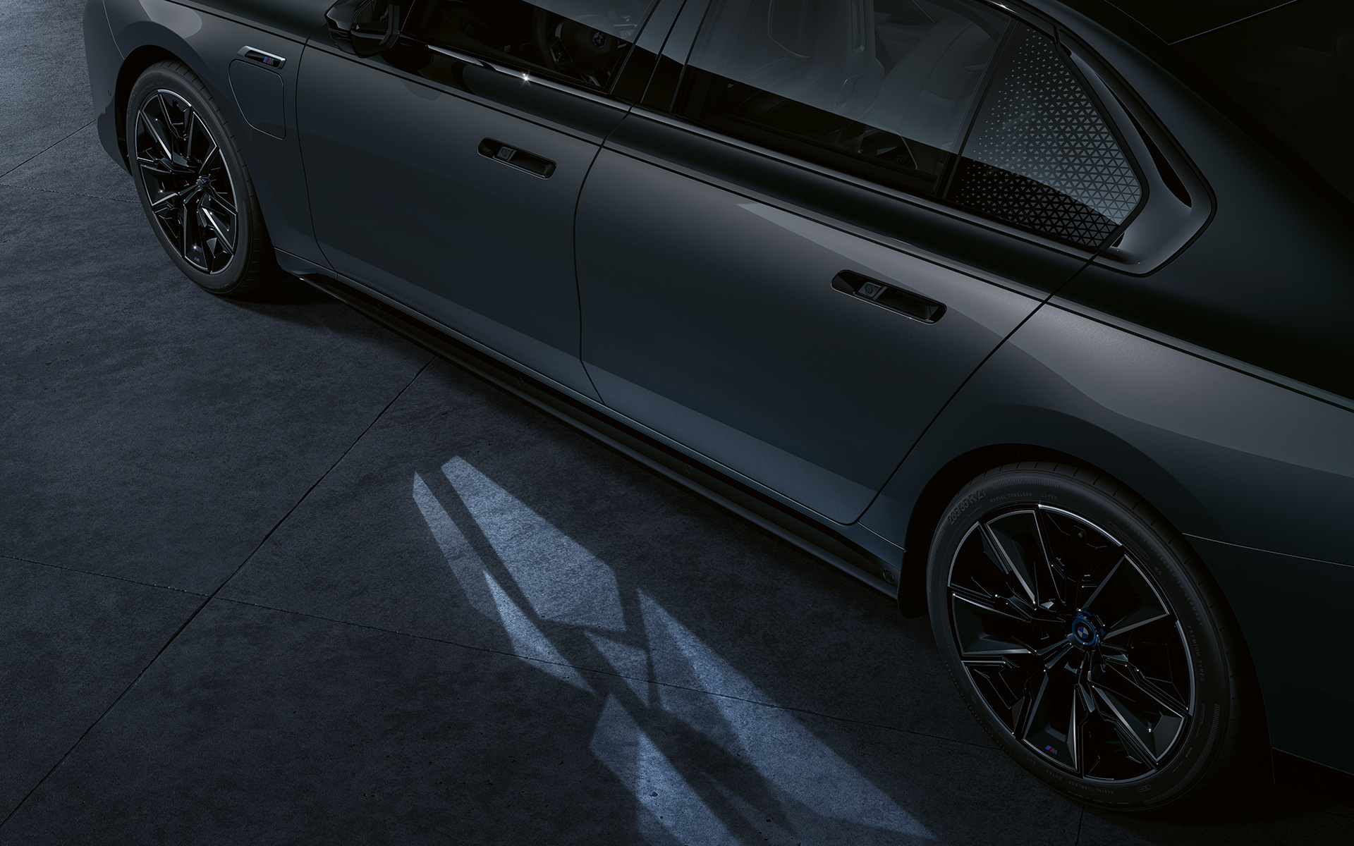 Concepto de iluminación BMW M760e xDrive Berlina G70 BMW Individual bicolor Black Sapphire metalizado, pintura BMW Individual Dravit Grey metalizado, detalle de la vista lateral con Welcome Light Carpet encendida