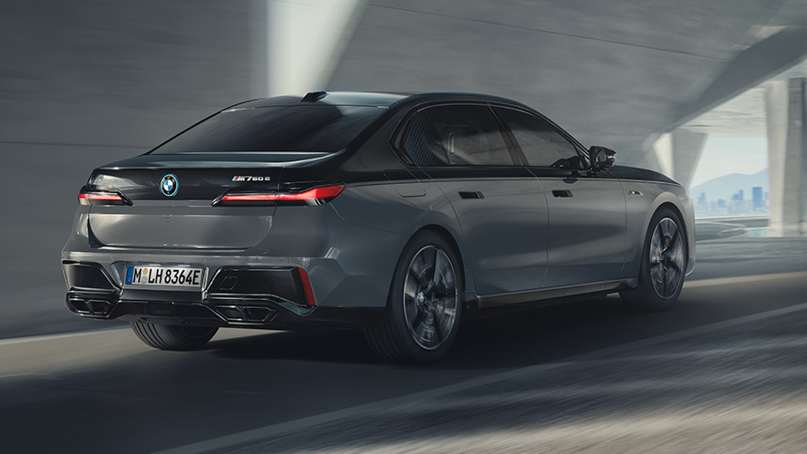 BMW M760e xDrive Berlina G70 Paquete M Performance BMW M760e xDrive Berlina G70 Paquete M Performance BMW Individual Black Sapphire metalizado bitono, pintura BMW Individual Dravit Grey metalizado, vista de tres cuartos de la zaga circulando por la calle