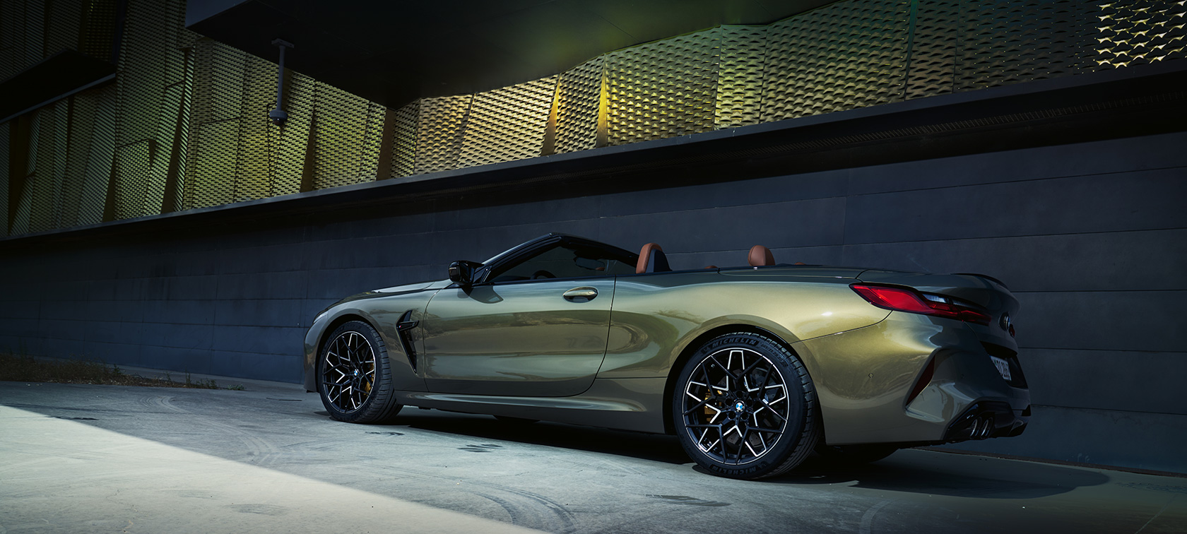 BMW M8 Competition Cabrio F91 LCI Renovación 2022 BMW Individual Brass metalizado, vista de tres cuartos del lateral, parado, delante de una pared
