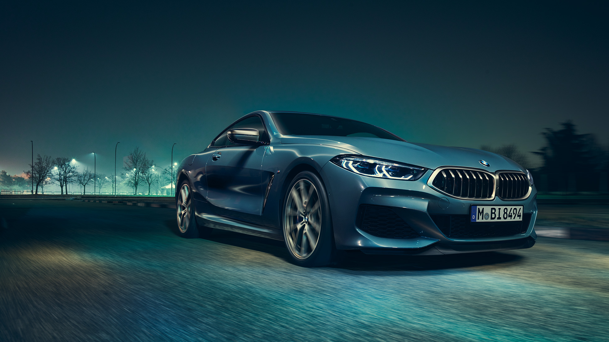 BMW M850i xDrive Coupé, vista de tres cuartos del frontal desde la izquierda. BMW M850i xDrive Coupé en Barcelona Blau metalizado, vista de tres cuartos del frontal desde la izquierda, en marcha, por la noche.